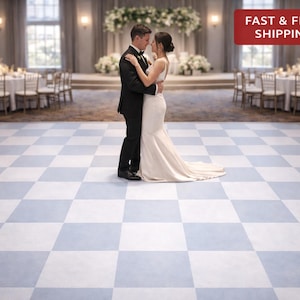 May include: A couple embraces on a checkered dance floor in a ballroom. The floor features a pattern of light blue and white squares. The background includes tables, chairs, and floral arrangements, suggesting a wedding or formal event.