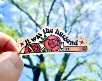 May include: A sticker with a knife and red roses, with the text "it was the husband" in a retro font.