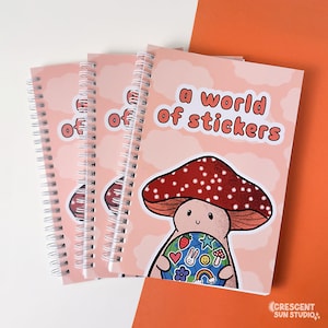 Spiral bound book with a background of peachy clouds. Coral text reads "a world of stickers." Below that is a happy mushroom holding a globe covered in stickers.