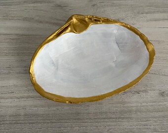Platos de baratijas con conchas marinas blancas y doradas