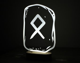 May include: A white illuminated lamp shaped like a stone with a white rune symbol on it. The lamp is on a black base.