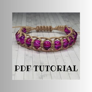 May include: A close-up of a purple and brown beaded bracelet with a knotted design. The bracelet is on a white wooden surface. PDF TUTORIAL is written in black text below the bracelet.