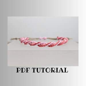 Op de afbeelding: Een roze en rood gevlochten vriendschapsarmband met een PDF-tutorial.