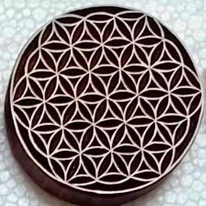 Könnte beinhalten: Ein runder Holz-Untersetzer mit einem weißen geometrischen Muster einer Lebensblume.