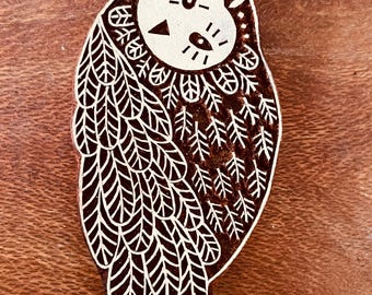 Può includere: Un timbro di legno a forma di gufo, marrone con dettagli bianchi. Il timbro presenta un design dettagliato di gufo con piume stilizzate e tratti del viso. Ideale per lavori di artigianato e progetti creativi.