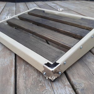 K&ouml;nnte beinhalten: Ein rechteckiges Pedalboard mit cremefarbenem Rahmen und dunklen Holzlatten. Das Pedalboard ist 45,7 cm lang, 33 cm breit und 8,9 cm hoch. Die Ecken sind mit silberfarbenem Metall verst&auml;rkt. Der Rahmen ist 3,8 cm dick.