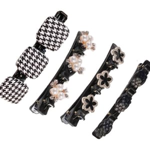 May include: Set of four black hair clips with different decorative elements. One clip features a black and white houndstooth pattern, another has pearl and rhinestone accents, another has black flower accents, and the last has black rhinestone accents.