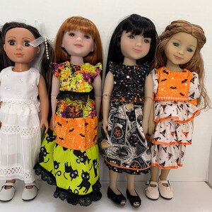 May include: Four dolls standing in a row. The first wears a white eyelet dress and white shoes. The second wears a tiered dress with orange, green, and black cat patterns. The third wears a black dress with occult symbols. The fourth wears a tiered orange and white dress with bat and witch hat prints.