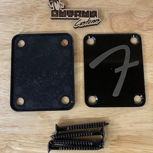 May include: Two black guitar pickup mounting plates, one with a Fender logo, and four black screws.
