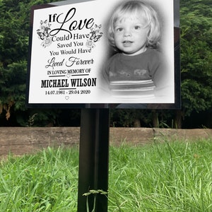 Grote begraafplaatsgrafmarkering met gepersonaliseerde fotoplaat, grote metalen staak, tijdelijke grafsteen, fotomonument.