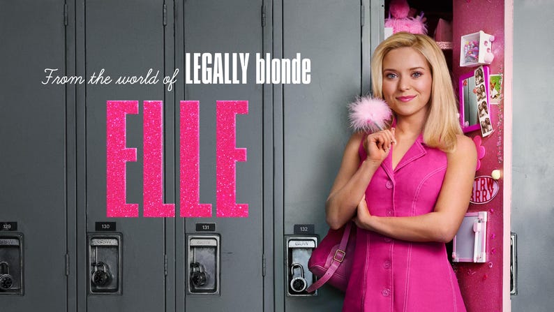 Op de afbeelding: Een blond persoon in een felroze mouwloze jurk met kraag, die een roze pompon-accessoire vasthoudt. De tekst luidt From the world of LEGALLY blonde en ELLE, tegen een achtergrond van grijze metalen schoolkluisjes.
