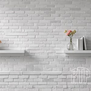 Puede incluir: Dos estantes blancos montados en una pared de ladrillo blanco. El estante superior tiene un jarrón de vidrio transparente con flores rosas y un jarrón de cerámica blanca. El estante inferior tiene una pila de libros.