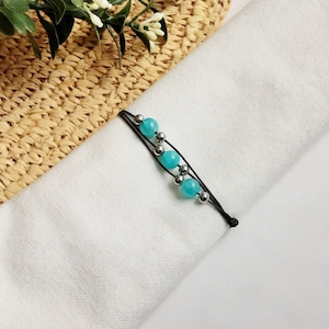 May include: A black elastic bracelet with turquoise and silver beads.