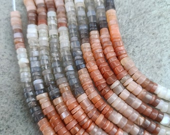 Può includere: Una collana di perle di pietra di sole in varie tonalità di arancione, rosa e grigio. Le perle sono sfaccettate e hanno una finitura liscia e lucida.