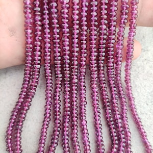 Puede incluir: Una hebra de cuentas de piedras preciosas de color morado oscuro. Las cuentas son pequeñas y redondas, y están enhebradas en un hilo transparente. La hebra mide aproximadamente 46 cm de largo.