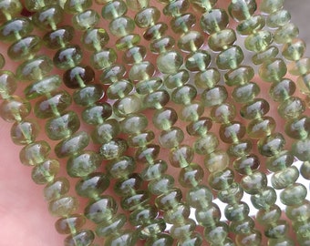 May include: A strand of green gemstone beads, each bead is round and slightly faceted. The beads are strung on a clear thread and are ready for jewelry making.