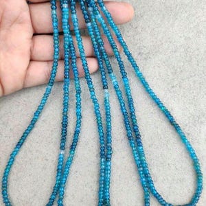 Può includere: Fili di piccole perline rotonde di pietre preziose blu. Le perline hanno diverse tonalità di blu, creando un effetto sfumato. Le perline sono infilate insieme, formando più collane o fili di gioielli.