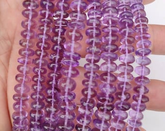 May include: A strand of amethyst beads, featuring a light purple color and a smooth, round shape. The beads are strung together on a clear thread, creating a delicate and elegant look.