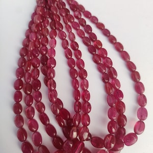 May include: A strand of oval-shaped, pink ruby beads. The beads are strung on a thin wire and are approximately 10mm in length.