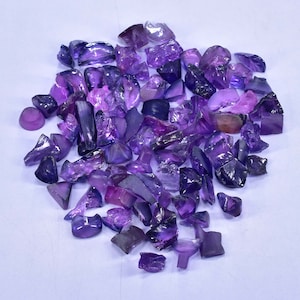May include: A large pile of purple amethyst gemstone rough. The rough is in various shapes and sizes.