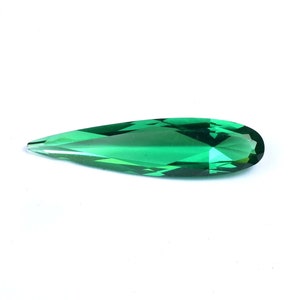 May include: A teardrop-shaped green gemstone with a faceted cut.