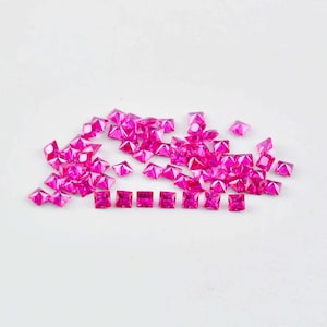 Puede incluir: Un montón de piedras preciosas cuadradas de color rosa, con una fila de piedras preciosas más pequeñas en primer plano.