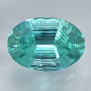 May include: A vibrant teal green gemstone with a faceted oval shape. The gem has a unique striated pattern, creating a mesmerizing visual effect.