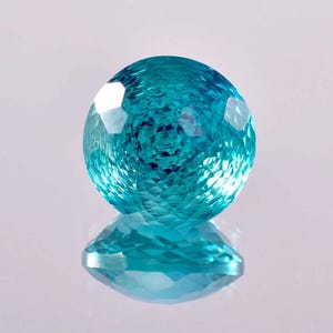 May include: A bright blue gemstone with a faceted cut, reflecting light in a shimmering pattern.