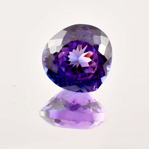 Puede incluir: Una gema púrpura y azul con un patrón en forma de estrella en el centro.