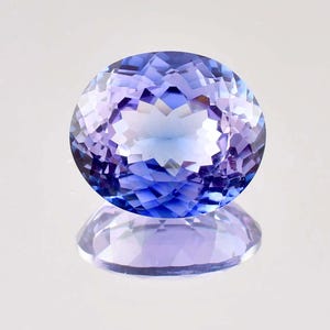 May include: A large, oval-shaped, faceted gemstone with a blue to purple color gradient. The gemstone is reflecting light, creating a shimmery effect.
