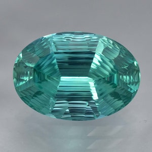 May include: A vibrant teal green oval-shaped gemstone with a faceted cut. The gemstone has a smooth, polished surface and a clear, transparent appearance.