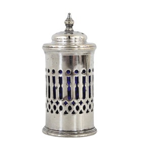 Puede incluir: Salero de plata con un inserto de vidrio azul y un diseño perforado.