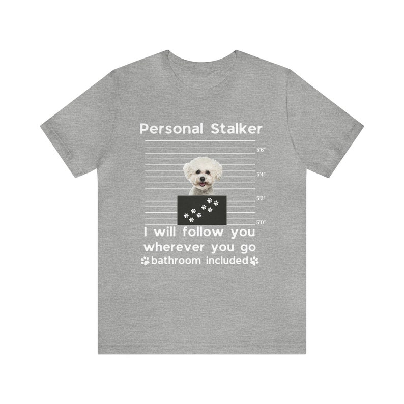 May include: A gray t-shirt with a white graphic of a white dog with black paw prints. The text "Personal Stalker" is above the dog and the text "I will follow you wherever you go bathroom included" is below the dog.