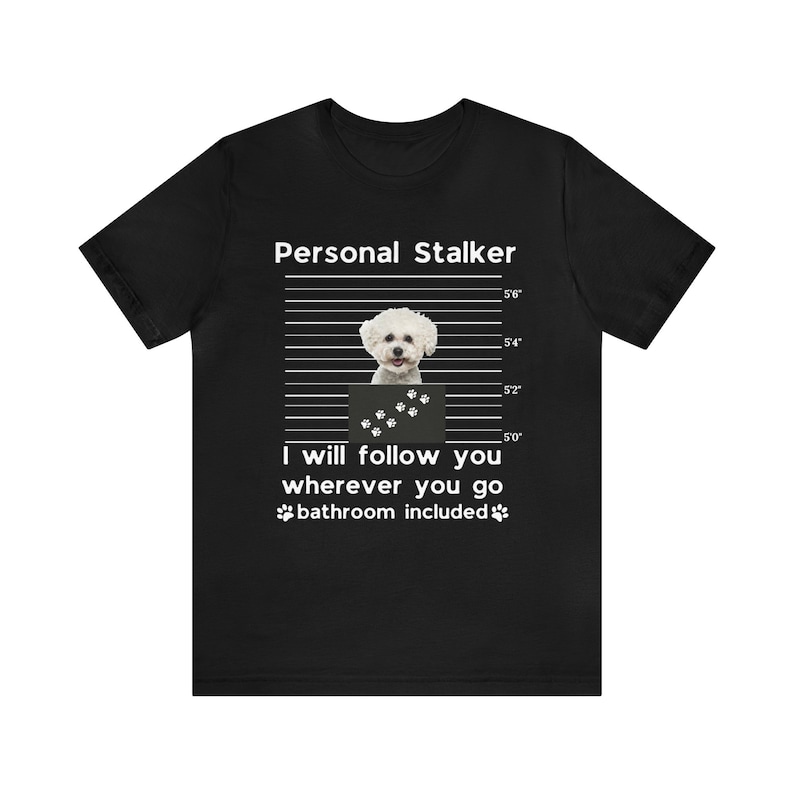 May include: A black t-shirt with a white graphic of a small white dog in a mugshot. The text "Personal Stalker" is above the dog and "I will follow you wherever you go bathroom included" is below the dog.