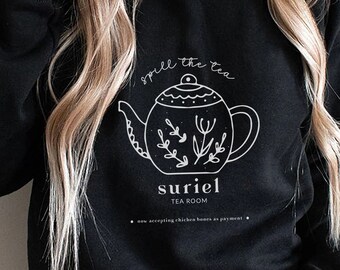 May include: Black sweatshirt with a white graphic of a teapot with the text "Smell the tea" and "Suriel Tea Room".