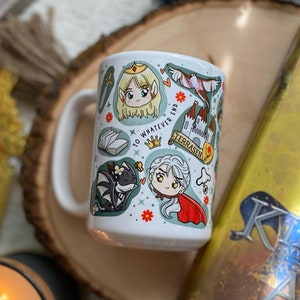 May include: A white ceramic mug with a handle, featuring a colourful cartoon design of characters and objects from the book "Throne of Glass" by Sarah J. Maas. The mug is sitting on a wooden surface with a book titled "Kingdom of Ash" by Sarah J. Maas.