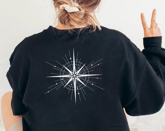 May include: Black sweatshirt with a white compass design on the back. The compass has a star in the center and lines radiating out from it.