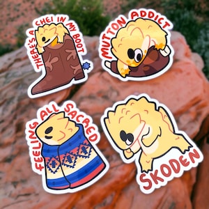 May include: Four colorful stickers featuring cartoon lizards with different phrases. The first sticker says "There's a chei in my boot". The second sticker says "Mutton addict". The third sticker says "Feeling all sacred". The fourth sticker says "Skoden".