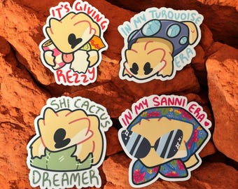 May include: Four colorful stickers featuring cartoon characters with different phrases. The stickers are on a red, orange, and brown textured background. The phrases on the stickers are "It's Giving Rezzy", "In My Turquoise Era", "Shi Cactus Dreamer", and "In My Sanni Era".