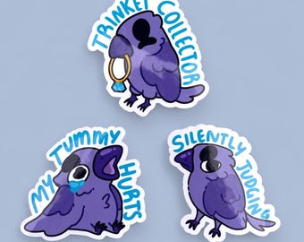 May include: Three purple bird stickers with different expressions and text. The first sticker says "Trinket Collector" and shows a bird holding a ring. The second sticker says "My Tummy Hurts" and shows a bird with a sad expression. The third sticker says "Silently Judging" and shows a bird with a serious expression.