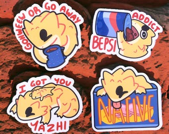 May include: Four stickers featuring cartoon bearded dragons with different sayings. One sticker says "Go meow or go away", another says "I got you Yazhi", another says "Addict", and the last one says "Native".