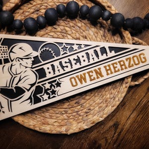 May include: A wooden pennant with a baseball player silhouette, stars, and the text "BASEBALL OWEN HERZOG".