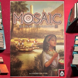 Pode incluir: Um tabuleiro de jogo verde e marrom com uma variedade de peças e fichas. O tabuleiro de jogo é rotulado como "Mosaic: A Story of Civilization" e apresenta uma imagem de uma mulher egípcia. O jogo é de Glenn Drover.