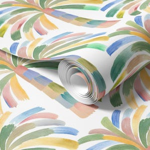 May include: Watercolor wallpaper featuring a repeating pattern of stylized palm trees. The trees are composed of brushstrokes in pastel colors, including pink, yellow, blue, and green, against a white background. The roll of wallpaper is partially unrolled, revealing the pattern.