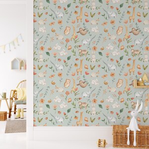 K&ouml;nnte beinhalten: Eine hellblaue Tapete mit einem sich wiederholenden Muster aus Tieren und Blumen. Zu den Tieren geh&ouml;ren Elefanten, Giraffen, Eulen, Faultiere und Kaninchen. Die Blumen sind in den Farben Rosa, Orange und Gelb gehalten.