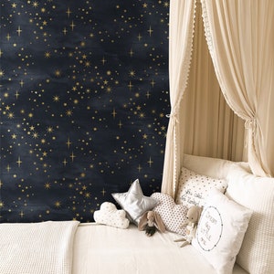 K&ouml;nnte beinhalten: Ein wei&szlig;es Himmelbett mit einer wei&szlig;en Decke und Kissen. Die Wand hinter dem Bett ist dunkelblau mit goldenen Sternen. Die Kissen haben den Text "You are so loved" und "Dream big little one".
