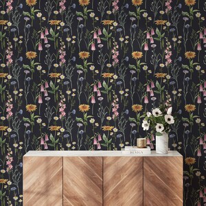 May include: A wooden cabinet with three drawers and a black marble top. The cabinet is in front of a black wallpaper with a floral pattern featuring pink, yellow, and white flowers.