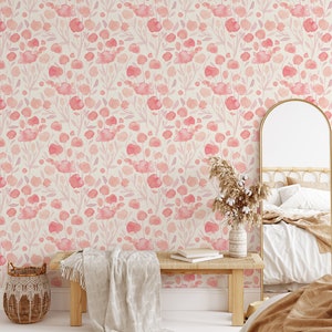 May include: A bedroom interior with a light pink floral wallpaper featuring a watercolor design. The room has a wooden bench with a white throw blanket, a wicker basket, a mirror, and a bed with a brown throw blanket.