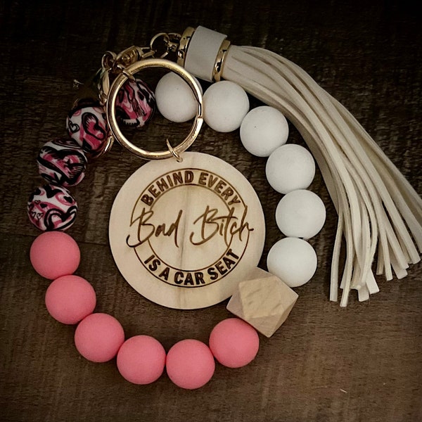 Behind Every Bad Bitch is a Car Seat Wristlet with tassel and engraved disc, add personalization, silicone bead or wooden bead wristlet