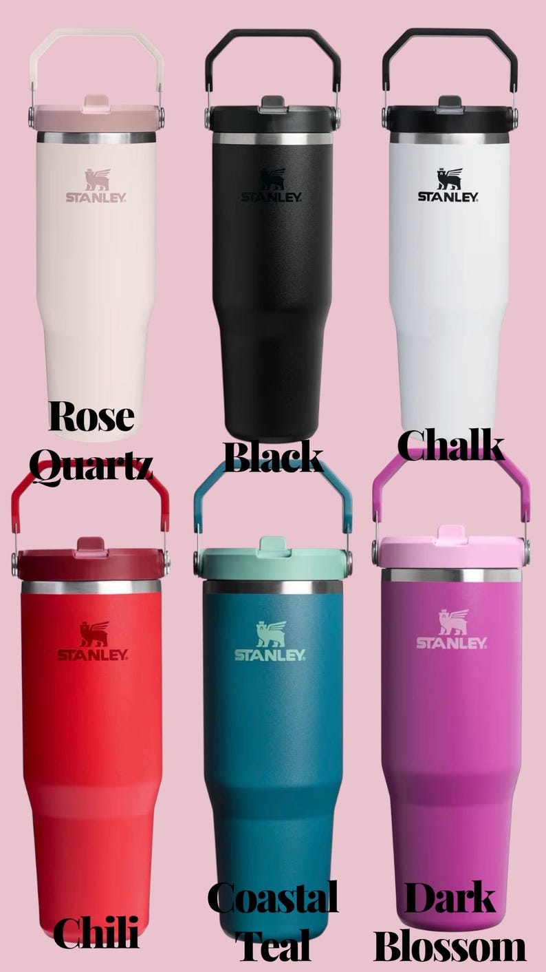 May include: A collection of Stanley brand insulated tumblers in various colors, including Rose Quartz, Black, Chalk, Chili, Coastal Teal, and Dark Blossom. Each tumbler features a handle and the Stanley logo.
